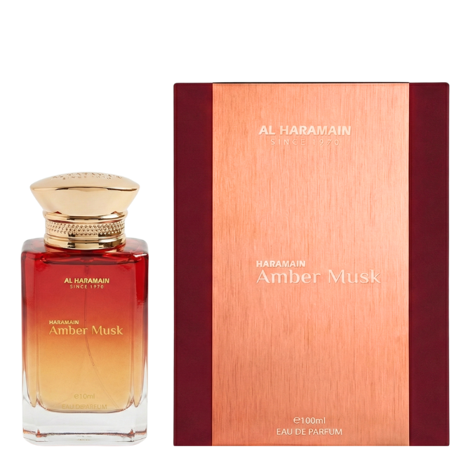 Al Haramain Amber Musk 100ml Eau De Parfum in a red-to-amber ombré glass bottle, presented next to its matching metallic copper and deep burgundy box.