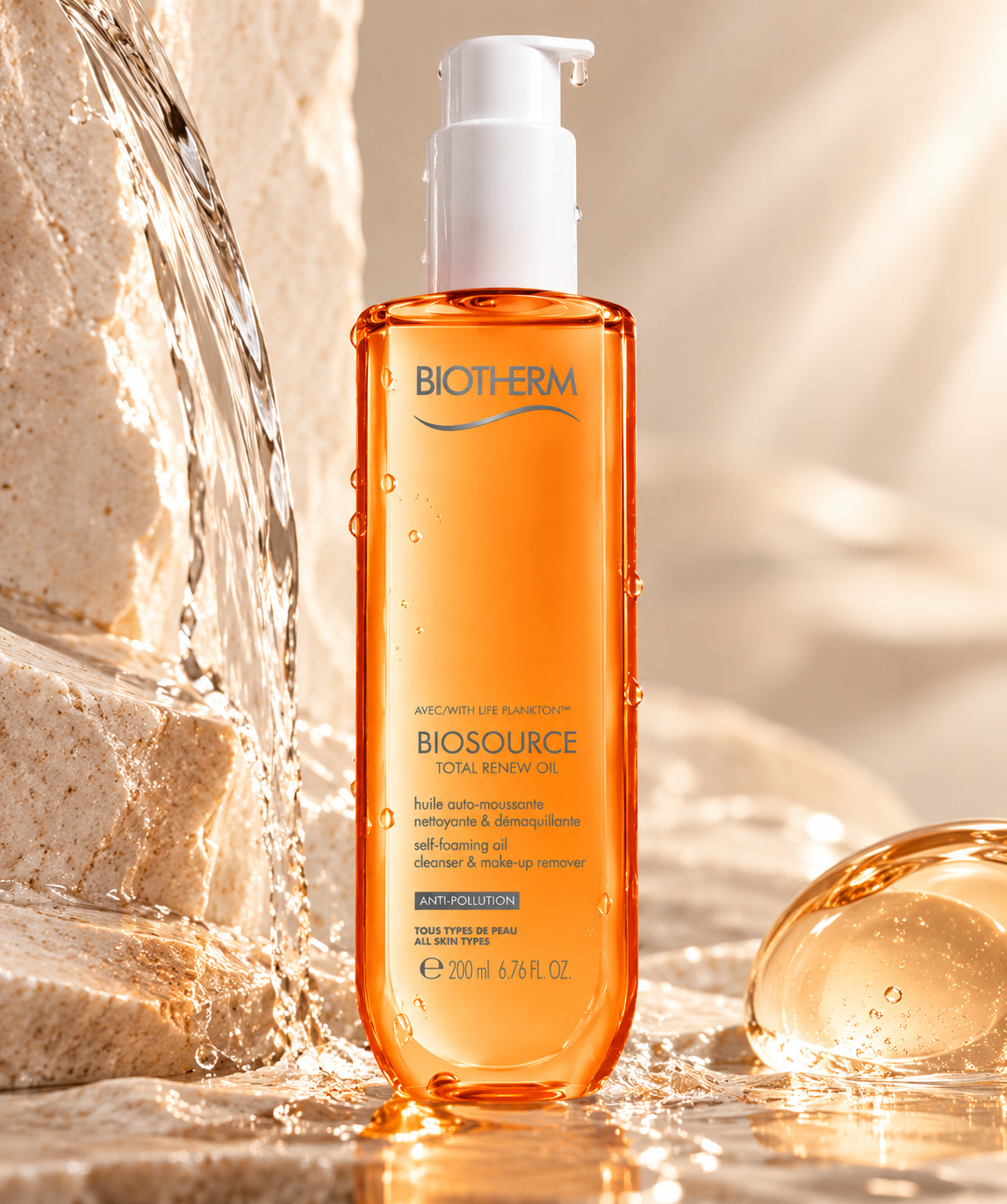 Biotherm Biosource Total Renew Oil cleansing oil and makeup remover displayed in a warm, fresh skincare setting with flowing water, droplets and soft natural light.