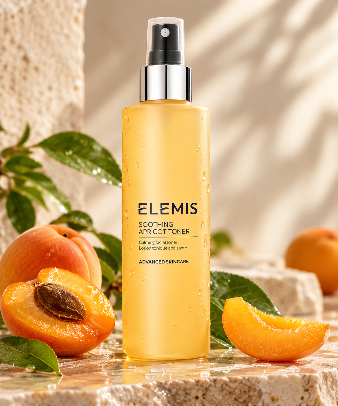 ELEMIS Soothing Apricot Toner presented in a golden spray bottle with delicate water droplets, surrounded by fresh apricots, green botanical leaves and natural stone. A luxurious calming facial toner that refreshes, hydrates and soothes the skin, beautifully displayed in warm natural light.